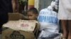  A Filipino boy sits inside an empty carton of noodles as he waits for his parents to receive relief goods at a hardly hit residential area in suburban Quezon City, north of Manila, Philippines, August 13, 2012. 