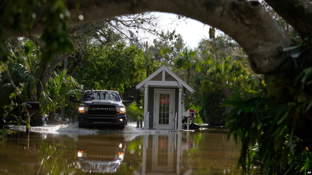 Una camioneta pasa junto a una puerta de guardia en una calle inundada en Siesta Key, Florida, luego del paso del huracán Milton, el 10 de octubre de 2024.