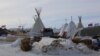  Both chopped firewood and donated wood for building shelter were buried under snow this week as a blizzard passed through the camp (E. Sarai / VOA)