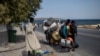 Migrants carrying their belongings, walk on a road near Mytilene town, on the northeastern island of Lesbos, Greece, Sept. 14, 2020. 