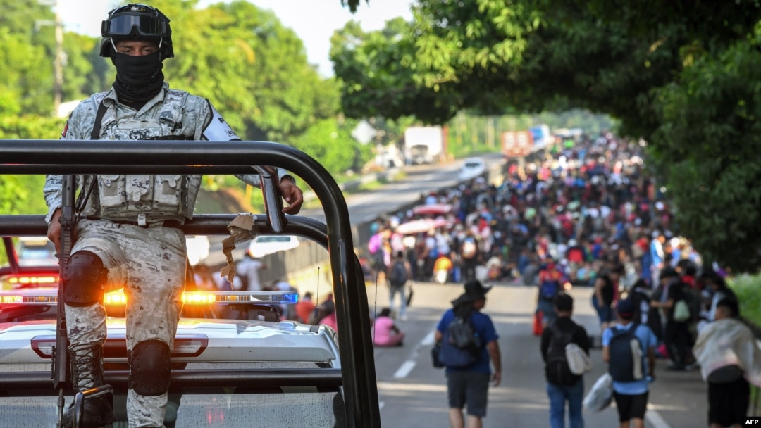 Un miembro de la Guardia Nacional escolta a migrantes que caminan en una caravana con destino a Estados Unidos en las afueras de Tapachula, Estado de Chiapas, México, el 23 de julio de 2024.