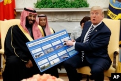 El presidente de EE.UU., Donald Trump, enseña príncipe heredero de Arabia Saudí, Mohammed bin Salman, un cartel que muestra las ventas de armas al reino saudita. Washington, 20 de marzo de 2018.