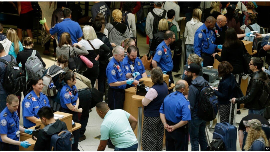 Agentes de Seguridad en el Transporte (TSA) revisan pasajeros en el aeropuerto internacional de Tacoma, en Washington.