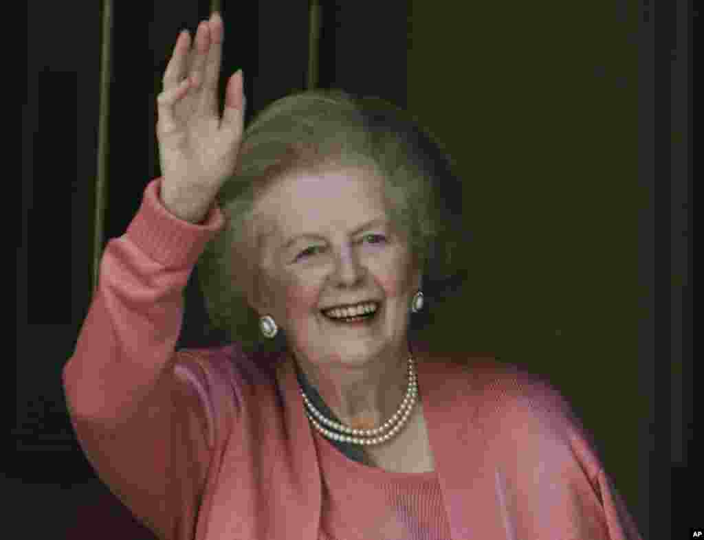 英国前首相撒切尔夫人2009年6月29日在从医院返回家中后，站在家门口向记者们招手。
