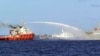 FILE - A Chinese ship (L) shoots a water cannon at a Vietnamese vessel (R) while a Chinese Coast Guard ship (C) sails alongside in the South China Sea, off Vietnam's coast.