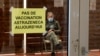 A man waits in a vaccination center where a sign reads 'No AstraZeneca vaccinations today' in Saint-Jean-de-Luz, southwestern France, March 16, 2021.
