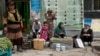 FILE - In this photo taken July 17, 2014, Uighur residents gather at a road side stall in the city of Aksu in western China's Xinjiang province. 