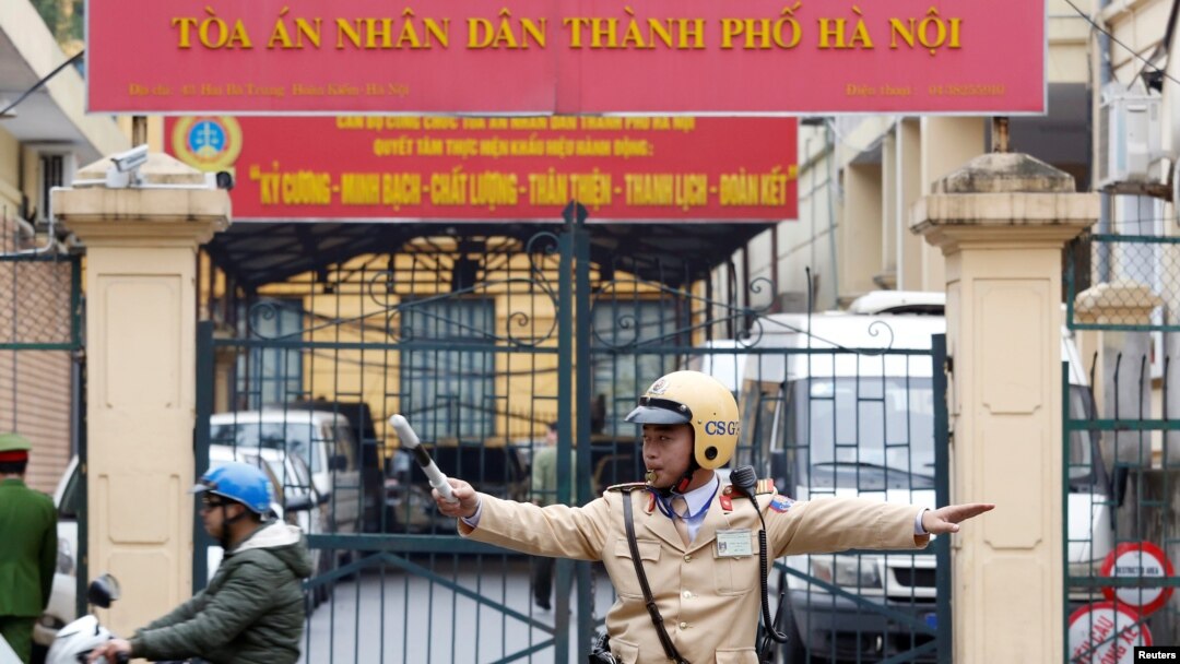 FILE - A policeman directs traffic in front of a court in Hanoi, Vietnam, Jan. 8, 2018. A court in the communist-run country's south reportedly sentenced two women Friday for anti-state propaganda.