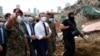 French President Emmanuel Macron, center, visits the devastated site of the explosion at the port of Beirut, Lebanon, Aug. 6, 2020. 