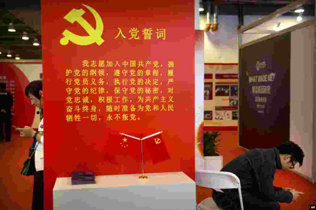 2018年9月26日，在北京的中国改革开放40周年展览会上，参观者使用智能手机。展品中有中共入党誓词。中共9000万党员中，有多少人真正相信这些誓词？