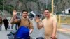 FILE - Two Russians wave toward a photographer after they crossed the border between Georgia and Russia at Verkhny Lars in Georgia, Sept. 28, 2022. 