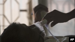 ARCHIVO - Un familiar ajusta la máscara de oxígeno de un paciente con tuberculosis, en un hospital en Hyderabad, India, el 24 de marzo de 2018.