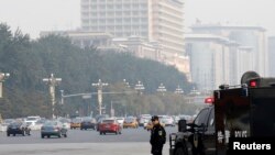 A Chinese policeman of the Special Weapons and Tactics (SWAT) team stands guard on a main street next to Tiananmen Square in Beijing, Oct. 31, 2013.