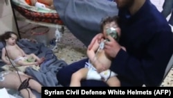 SYRIA -- Unidentified volunteers give aid to children at a hospital following an alleged chemical attack on the rebel-held town, April 8, 2018.