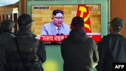 1일 한국 서울역 대합실에서 시민들이 북한 김정은 국무위원장의 신년사 관련 TV 뉴스를 보고 있다.