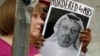 FILE - People hold signs during a protest at the Embassy of Saudi Arabia about the disappearance of Saudi journalist Jamal Khashoggi, in Washington,Oct. 10, 2018. 