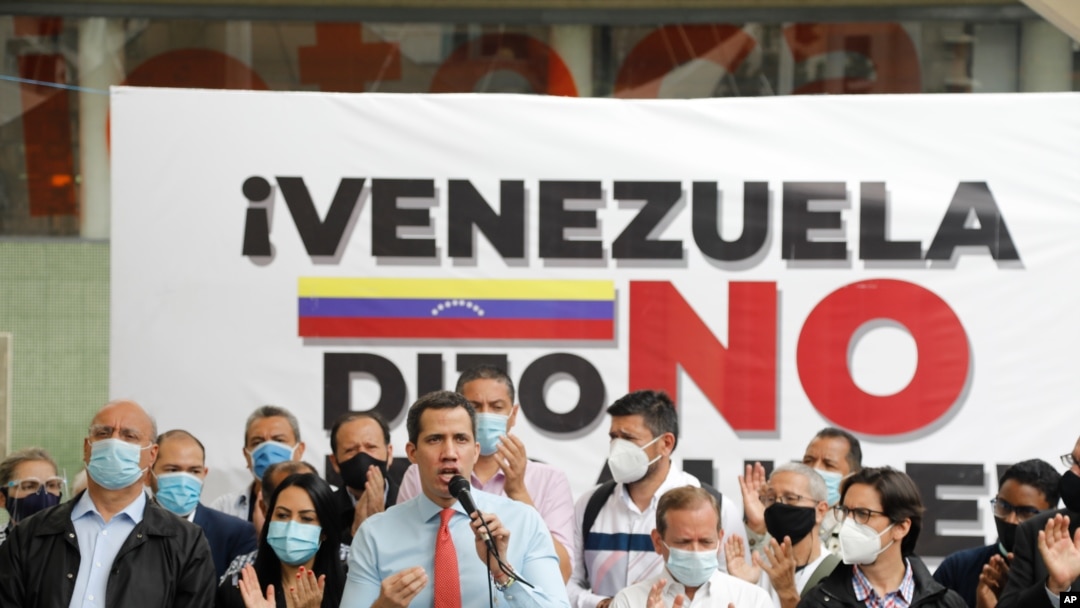 Flanqueado por compañeros, el líder de la oposición venezolana Juan Guaidó habla durante una conferencia de prensa, un día después de las elecciones parlamentarias, en Caracas. Diciembre 7, 2020.
