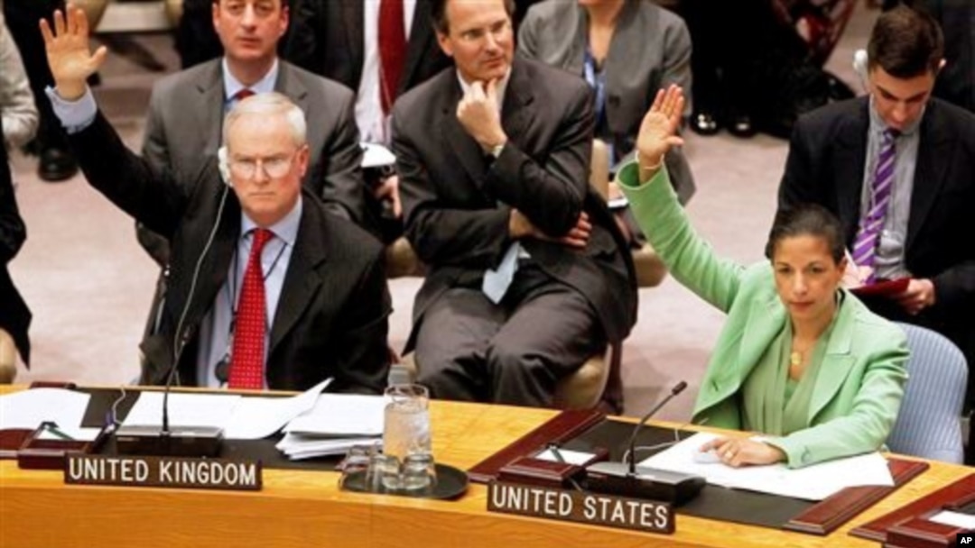 Permanent representatives from the United Kingdom, Mark Lyall Grant, left, and the United States, Susan Rice, right, vote to approve a resolution that will impose a no-fly zone over Libya during a meeting of the United Nations Security Council at UN headq