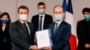 Historian and Commission chief on the France's role in 1994's Rwandan genocide, Vincent Duclert, right, gives a report to French President Emmanuel Macron, at the Elysee Palace, in Paris, March 26, 2021. 