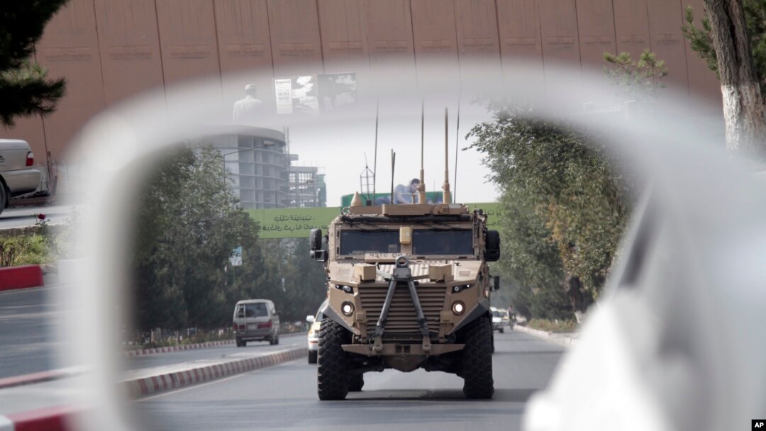 A patrolling U.S. armored vehicle is reflected in the mirror of a car in Kabul, Afghanistan, Aug. 23, 2017. 