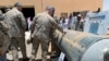 FILE - Saudi-led coalition officials show to U.S. Central Command chief General Kenneth McKenzie an exibit of weapons and missiles that is used by Houthi attacks against Saudi Arabia, in Riyadh.