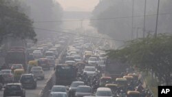 FILE - Commuters drive amidst morning haze and toxic smog in New Delhi, India, Nov. 17, 2021. 