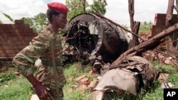 Umusirikare wa FPR ahagaze iruhande rw'ibisigazwa by'indege yari itwaye Perezida Habyarimana na Ntaryamira w'Uburundi. Mu bo bari kumwe harimo Jenerali Nsabimana