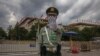 A Chinese People's Liberation Army (PLA) soldier wearing a protective face mask gestures to the photographer to stop taking photos in front of the Great Hall of the People, after the second plenary session of China's NPC, Beijing, May 25, 2020. 
