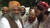 FILE - Maulana Fazl-ur-Rahman, left, leader of Pakistan's Jamiat Ulema-e-Islam party, is received by followers as he arrives in Pakistan at a border post near Lahore after a trip to India, July 24, 2003.