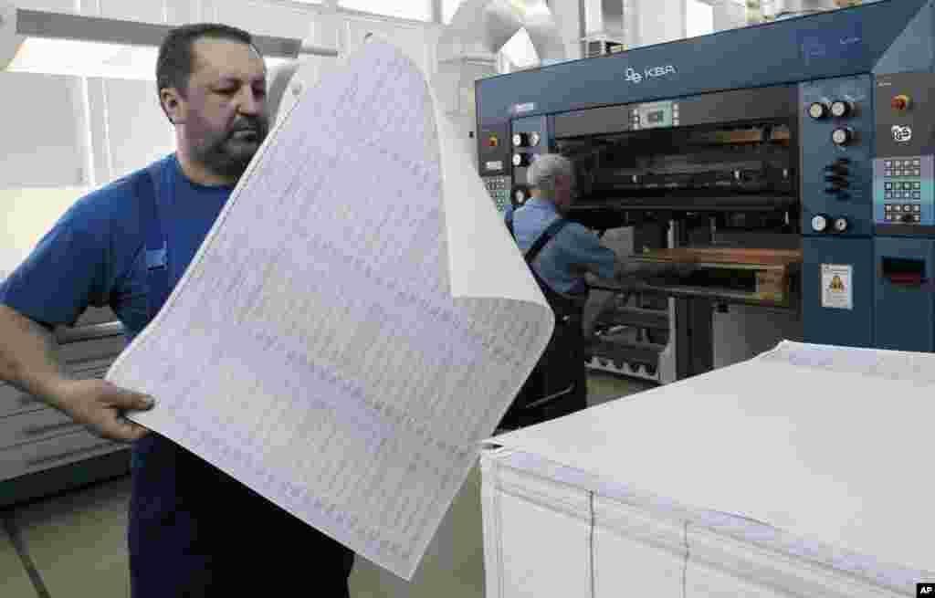 A worker at the state-owned printing house inspects a ballot for the May 25 snap presidential elections with 21 candidates taking part, in Kyiv, May 14, 2014.