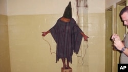 Zatvorenik iz Abu Grraiba u Bagdadu, na fotografiji snimljenoj krajem 2003. godne. (Foto: AP) 