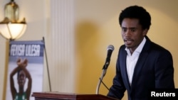 FILE - Rio Olympic marathon silver medalist Feyisa Lilesa of Ethiopia attends a news conference in Washington, Sept. 13, 2016. 
