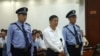 The Chinese court sentences Bo Xilai, center, to life in prison after finding him guilty on charges of bribery, embezzlement and abuse of power in a case set in motion by his wife's murder of a British businessman (File photo).