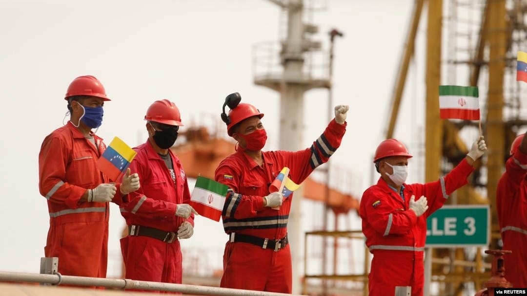 Trabajadores de la compañía estatal Pdvsa ondean banderas iraníes y venezolanas mientras atraca el petrolero Fortune, en la refinería El Palito, en Puerto Caballero, Venezuela. Mayo 25, 2020.