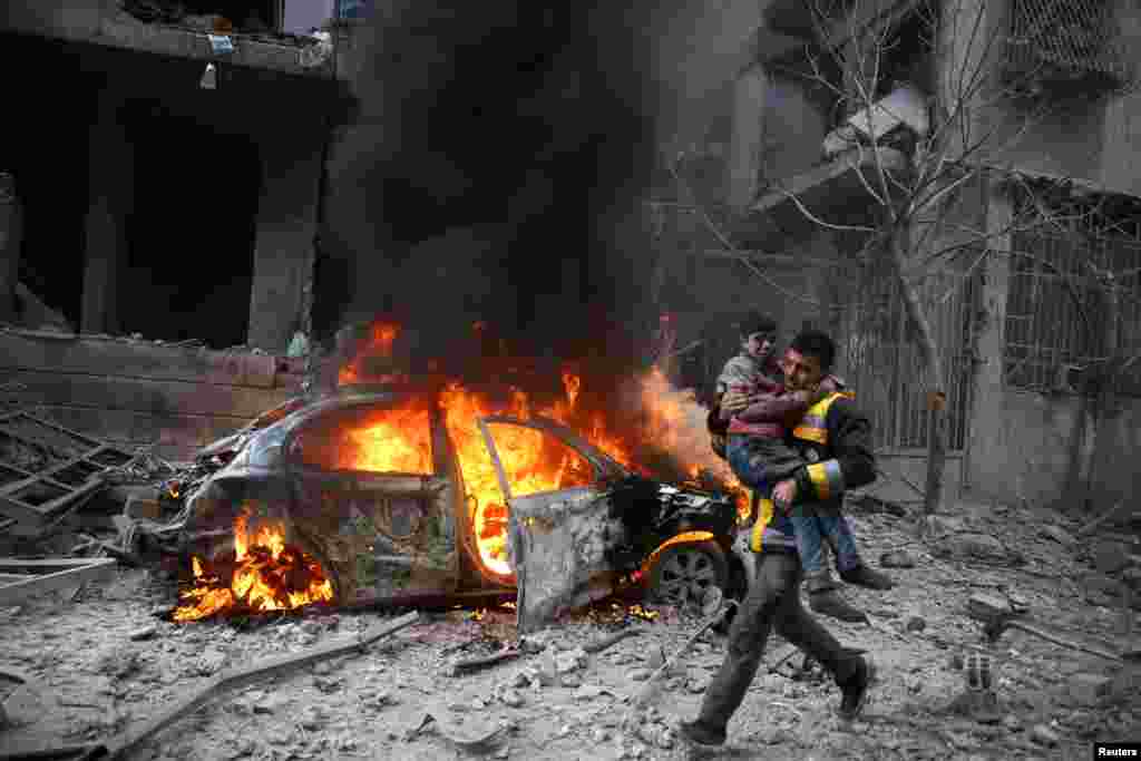 A Syria Civil Defense member carries a wounded child in the besieged town of Hamoria, Eastern Ghouta, in Damascus, Syria, Jan. 6, 2018. 