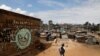 FILE - A boy walks in front of a graffiti promoting the fight against the coronavirus disease, in the Mathare slums of Nairobi, Kenya, May 22, 2020. Kenya reimposed some COVID-19 lockdown restrictions on March 26, 2021. 