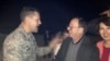 FILE - Jeffrey Fowle and his wife, Tatyana, are greeted by U.S. Air Force Col. John Devillier upon arrival at Wright-Patterson Air Force Base in Ohio after his release in North Korea, Oct. 22, 2014. 