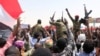 Sudanese military officers and demonstrators ride atop a military tanker as they protest against the army's announcement that President Omar al-Bashir would be replaced by a military-led transitional council, near Defense Ministry in Khartoum, Sudan, April 12, 2019.