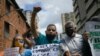 Un hombre grita consignas mientras sostiene una pancarta en una manifestación de maestros en Caracas, el 5 de Octubre de 2020.