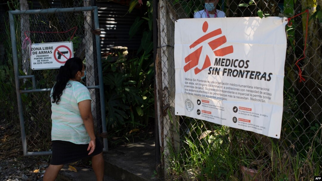 Una residente llega para una consulta médica en una clínica de la organización Médicos sin Fronteras (MSF) instalada en la comunidad del 1 de diciembre con un letrero que dice "Zona libre de armas".