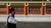 A man walks past portrait of communist party members on display outside Imperial Ancestral Temple in Beijing, China, November 12, 2012.