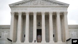 In this Oct. 9, 2018 photo, police office guards the main entrance to the Supreme Court. The court is taking up its first gun rights case in nine years, a challenge to New York City's prohibition on carrying a licensed, locked and unloaded handgun outside the city limits.