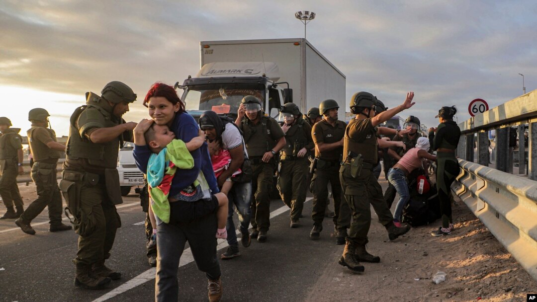 Migrantes que bloquean la carretera en la frontera entre Chile y Perú son dispersados por la policía chilena cerca de Arica, Chile, el martes 2 de mayo de 2023. 