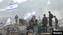Soldados israelitas em cima de tanques, perto da fronteira entre Israel e Gaza.