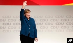 FILE - German Chancellor and chairwoman of the German Christian Democratic Union (CDU), Angela Merkel, waves after her farewell speech during a party convention of the CDU in Hamburg, Germany, Dec. 7, 2018.