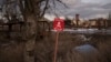 FILE - A sign that reads "Mines" is placed on the side of the road in the village of Kamyanka, Ukraine, on Feb. 19, 2023. In this war-scarred city in Ukraine's northeast, residents scrutinize every step for land mines. 