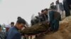 FILE - Mourners carry a covered body during a burial ceremony following a suicide attack on a hospital, at a cemetery in Kabul, Afghanistan, May 13, 2020. 
