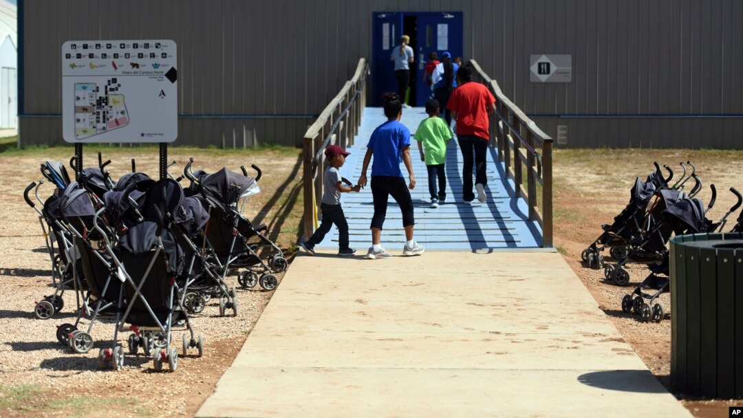 FILE - Photo provided by U.S. Immigration and Customs Enforcement shows immigrants walking into a building at South Texas Family Residential Center in Dilley, Texas.