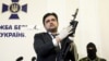 Markian Lubkivskyi, adviser of Ukraine's Security Service (SBU), shows a Kalashnikov automatic rifle with grenade launcher seized from a man identified by SBU as one of two Russian servicemen recently detained by Ukrainian forces, in Kyiv, May 21, 2015.