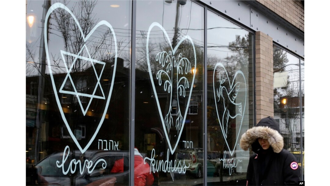 A woman walks past the window of a Starbucks in the Squirrel Hill neighborhood of Pittsburgh, Nov. 20, 2018. In the wake of the Tree of Life massacre, Squirrel Hill residents aren't shying away from celebrating Thanksgiving. They’re welcoming it.